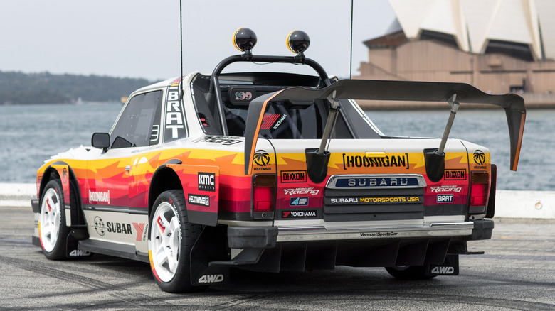 A rear three-quarters shot of the Brataroo parked on asphalt in front of the water and the Sydney Opera House