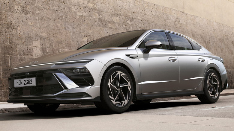 A silver 2026 Hyundai Sonata in front of a tan-colored building.