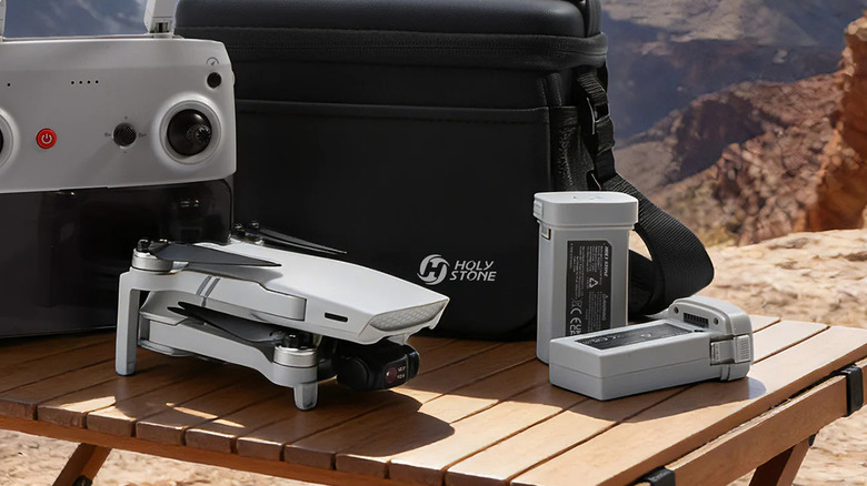 A Holy Stone HS900 Pro sitting on a park table with a complete kit