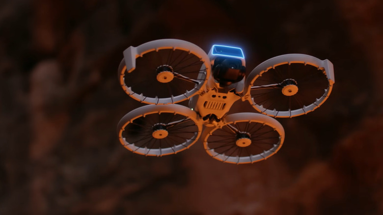 A DJI Flip drone hovering against a dark orange bokeh background