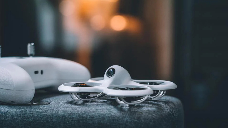 A BetaFPV Cetus Pro drone resting on a footrest next to a controller
