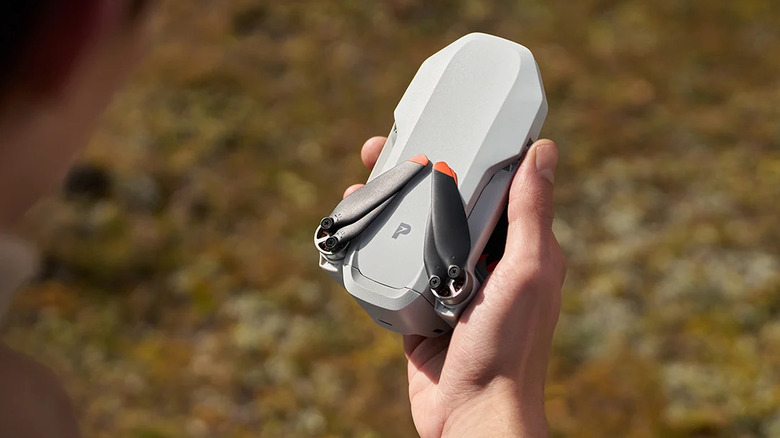 A person holding a Potensic Atom 2 folded to fit into the palm