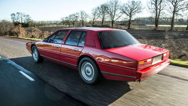 A rear-quarter dynamic shot of a red Aston Martin Lagonda on the road