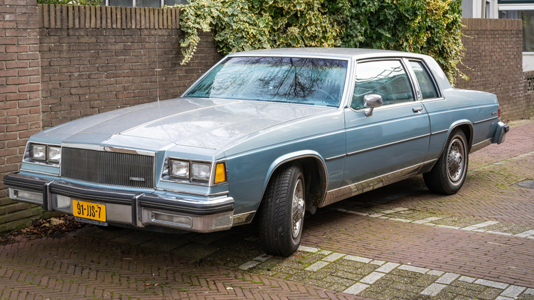 A late-model Buick parks on the street.