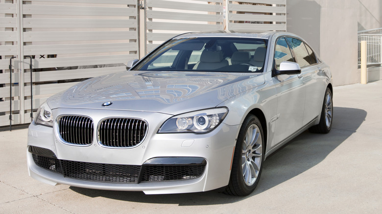 A last-generation luxury sedan parked outside.