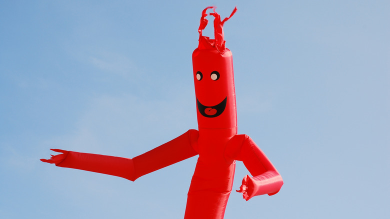 A red inflatable tube man draws attention to a business.