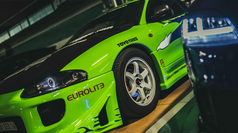 A bright green tuner car parked indoors.