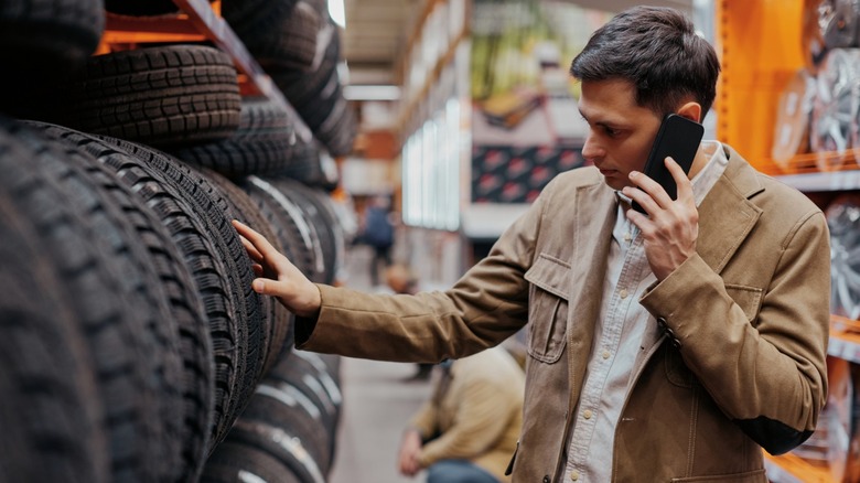 Man browsing tires at a store.