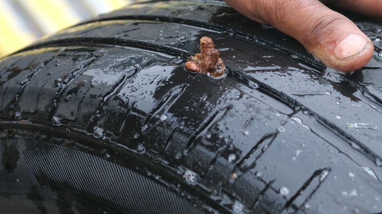 A brown tire repair plug inserted into tire tread.