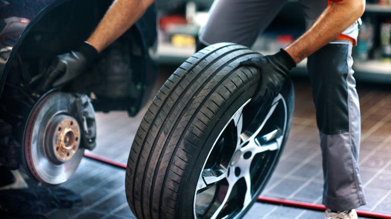 Man installing a new tire on a car.