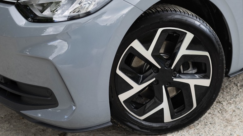 New front tire on a metallic grey car.
