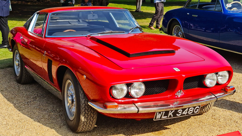 A red 1968 Iso Grifo 7-liter pictured on a concours lawn