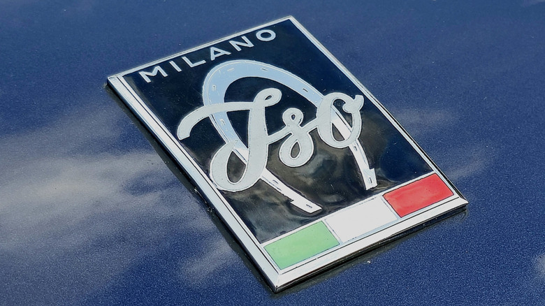 A close-up shot of an Iso Grifo hood badge on a blue paint job
