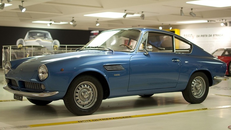 A blue ASA 1000 GT indoors with other cars