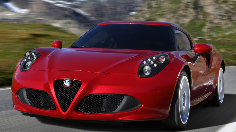 A red Alfa Romeo 4C driving on a mountain road