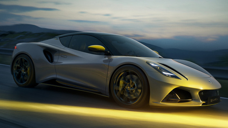 A gray Lotus Emira Turbo SE with yellow accents driving in low light