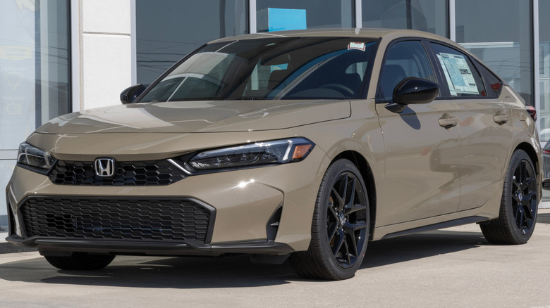 A brown Honda Civic sedan parked outside a dealership.