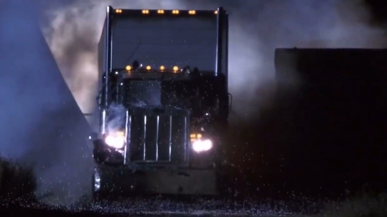 The semi-truck from Joy Ride driving through a wreck.