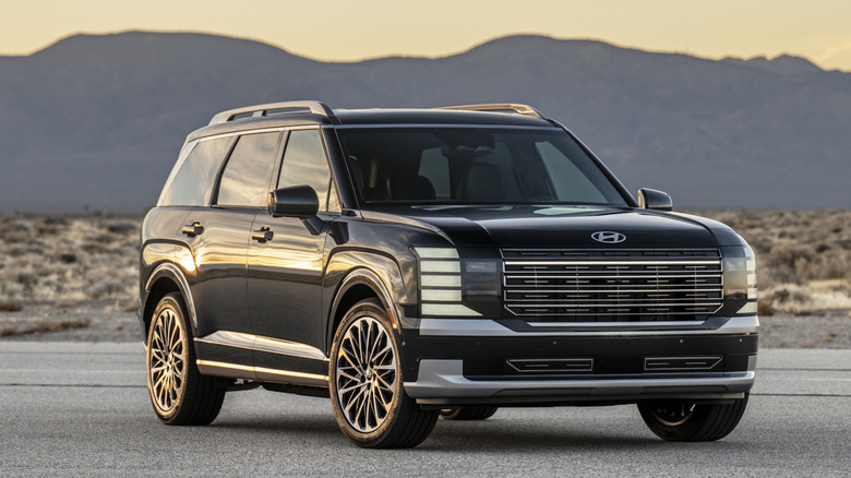A black 2026 Hyundai Palisade Hybrid on pavement with a mountain in the background.
