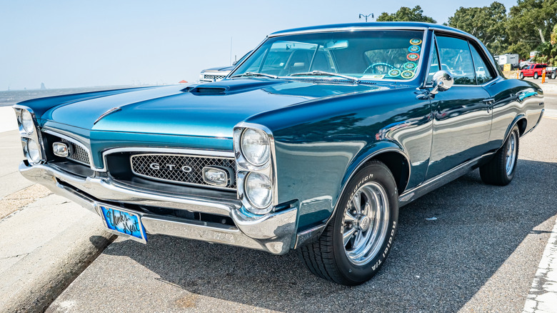 A rare blue 1967 Pontiac GTO two-door parked by the ocean.