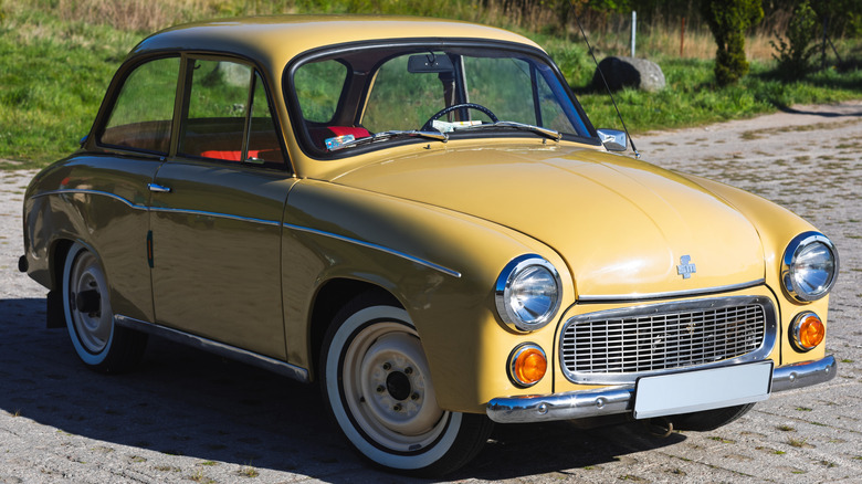 Golden-yellow FSO Syrena sits parked outdoors.