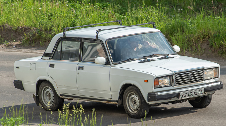 Vintage Lada Riva 2107 driving down a road.