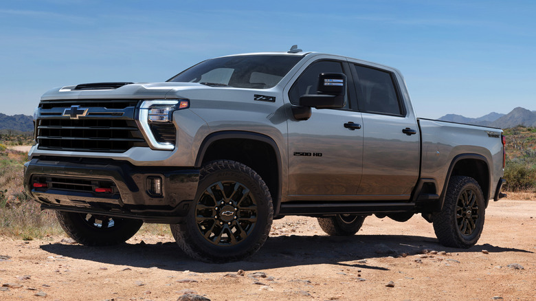 A front 3/4 static view of a gray 2026 Chevrolet Silverado HD Trail Boss parked in the desert