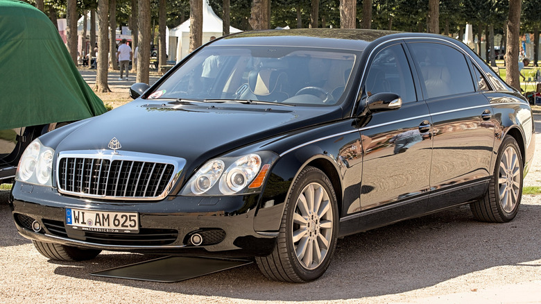 A front 3/4 view of a black Maybach 62 S in front of a park with numerous trees