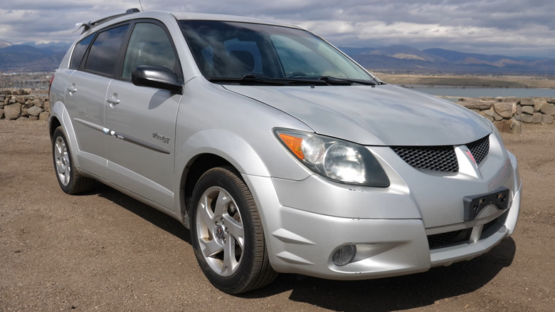 A silver first-generation Pontiac Vibe GT hot hatch parked at an outdoor scenic overlook.