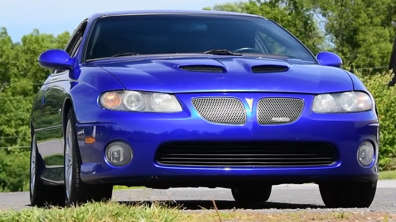 A blue metallic 2005–2006 Pontiac GTO coupe with dual hood scoops and split kidney grilles.