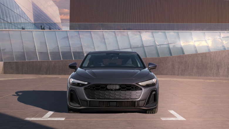 A gray 2026 Audi A5 parked in front of a modern-architecture building.