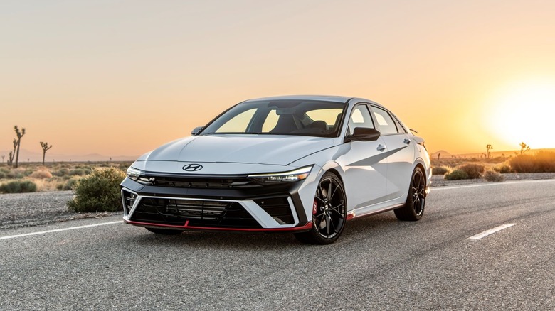 A white 2026 Hyundai Elantra N on a desert roadway at sunset or sunrise