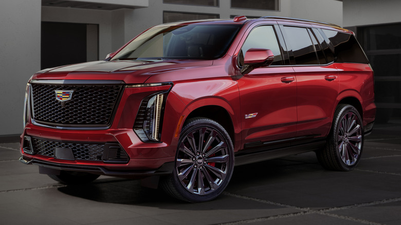 A red 2025 Cadillac Escalade-V in front of a building.