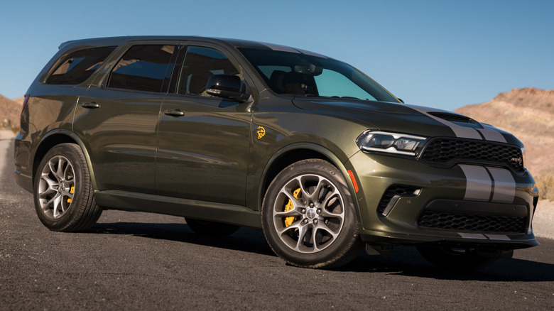 A green and silver-striped Dodge Durango SRT Hellcat parked on desert road.