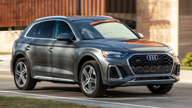 A gray 2021 Audi Q5 plug-in hybrid in front of a building.