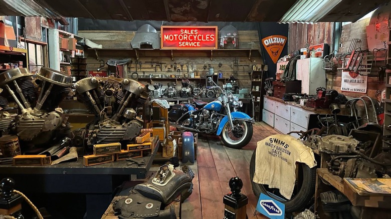 A picture of a blue vintage motorbike on display inside a replica mechanic's workshop inside Dale's Wheels Through Time museum.