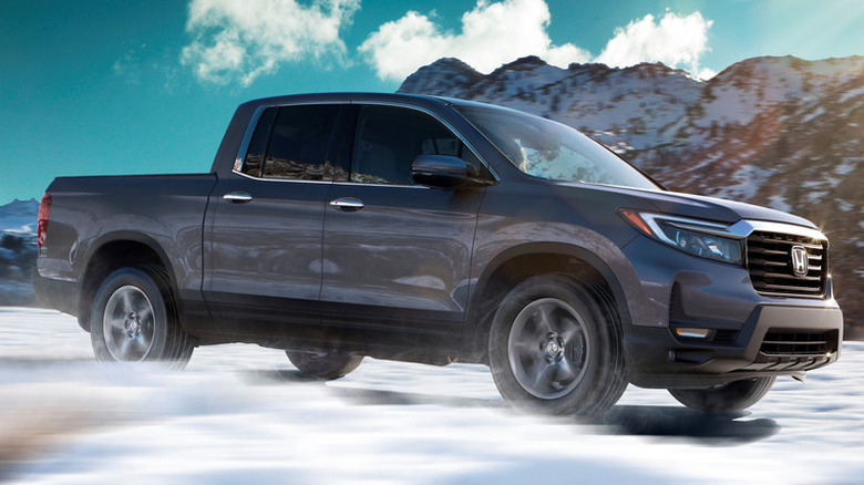 A dark-colored 2021 Honda Ridgeline driving in snow