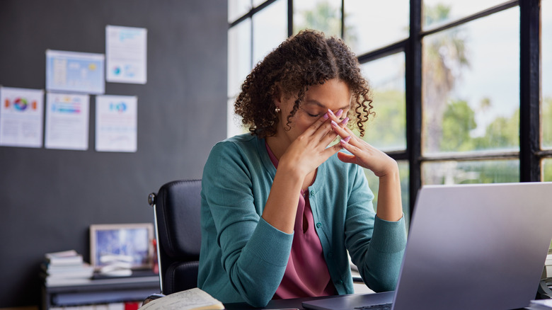 A salesperson hands a set of car keys to a toddler being held by an adult woman