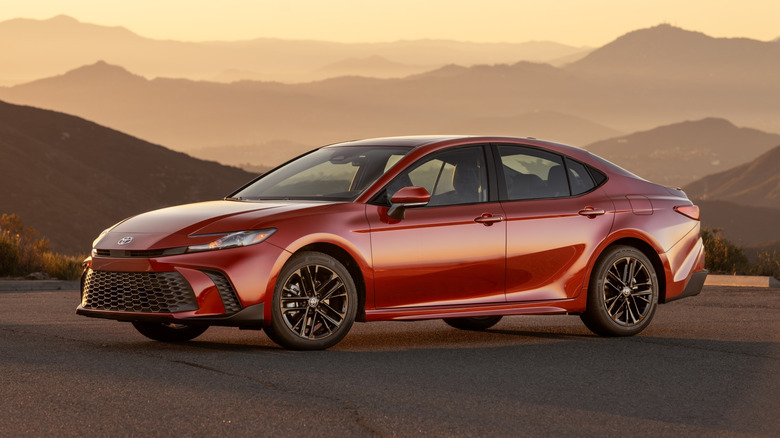 Red 2026 Toyota Camry seen from left front overlooking hazy mountains