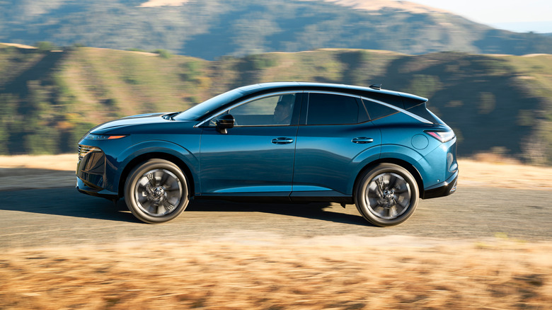 Blue 2026 Nissan Murano SUV left view with desert mountains in background