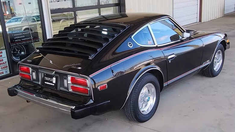 A Datsun 280Z Black Pearl is photographed from the rear with black window louvers.
