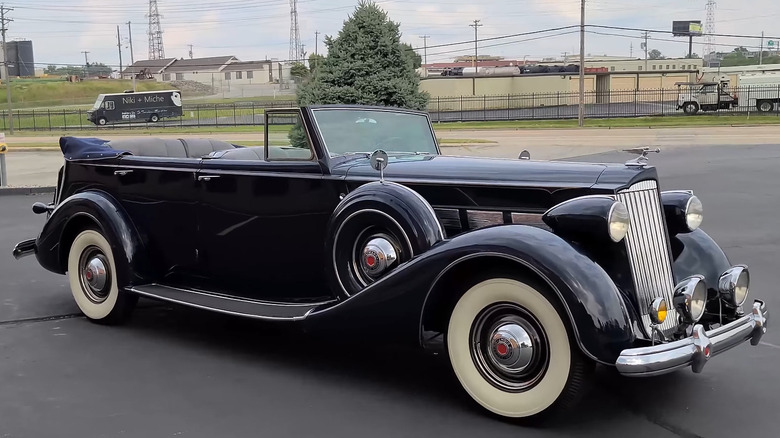 A Packard Blue Super Eight Convertible sedan parked in a paved lot.