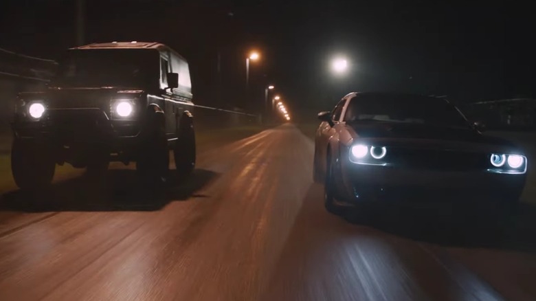 An action screenshot of Luke Hobbs' Land Rover driving alongside a modern Dodge Challenger from "The Fate of the Furious"
