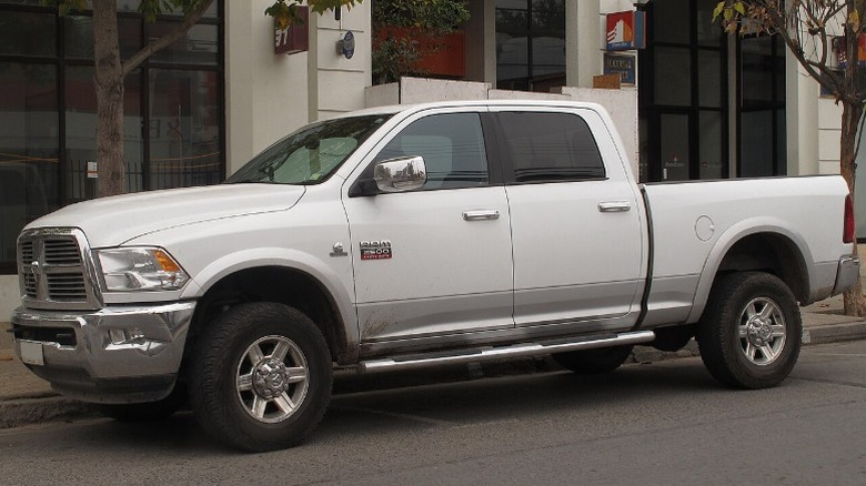 A white 2013 RAM 2500 parked by the sidewalk