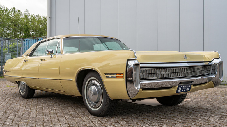A '70s Chrysler Imperial LeBaron parks outside a building.