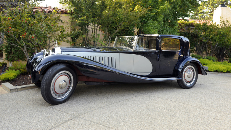 A Bugatti Type 41 Royale parked in a courtyard with the top down.