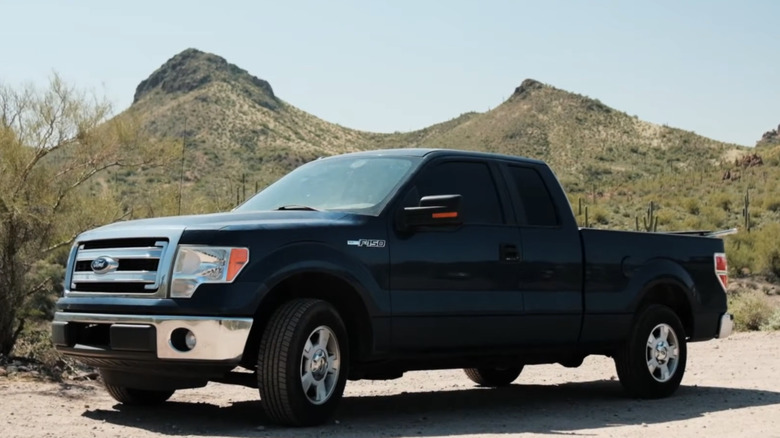 A 2013 Ford F-150 is parked near mountains.