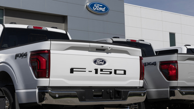 A Ford sign gleams above F-150 pickups parked below.