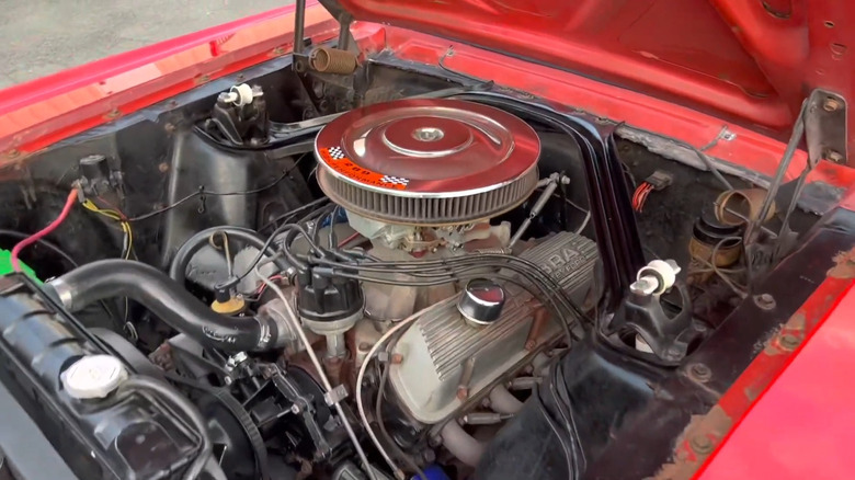 A Ford 289 cubic-inch Windsor V8 under the hood of a red 1965 Ford Mustang Fastback K Code HiPo