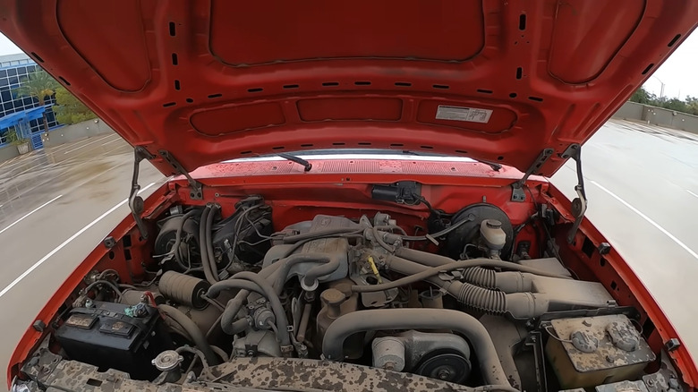A Ford 300-Series 4.9-liter inline-six engine under the hood of a a red F-Series truck
